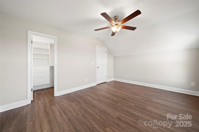 unfurnished bedroom with lofted ceiling, dark wood-type flooring, ceiling fan, a spacious closet, and a closet