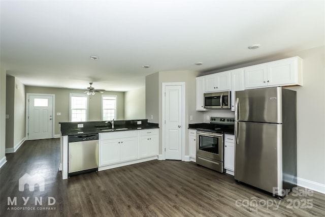 kitchen with white cabinetry, stainless steel appliances, kitchen peninsula, and sink