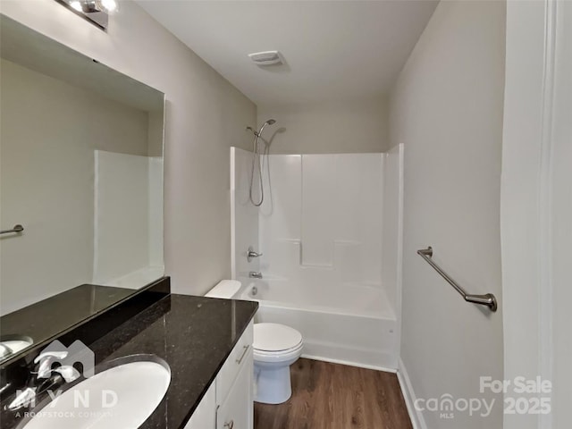 full bathroom with vanity, hardwood / wood-style flooring, tub / shower combination, and toilet