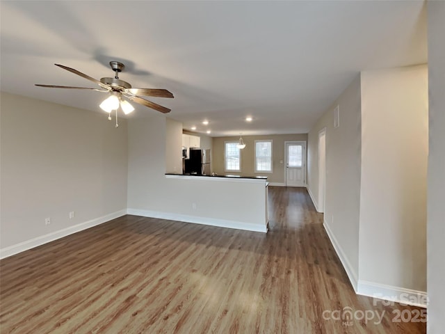 unfurnished living room with ceiling fan and light wood-type flooring