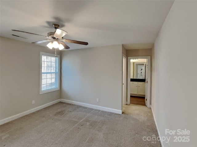 spare room with ceiling fan and light carpet