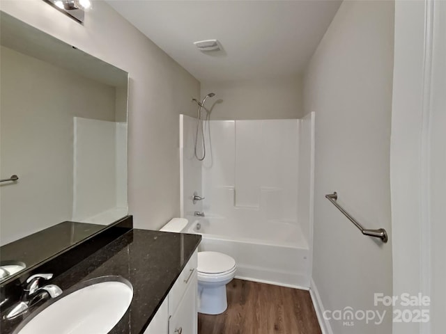 full bathroom featuring hardwood / wood-style flooring, vanity, toilet, and shower / washtub combination