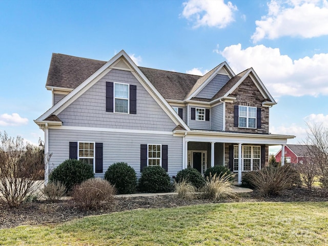 view of front of house featuring covered porch and a front yard