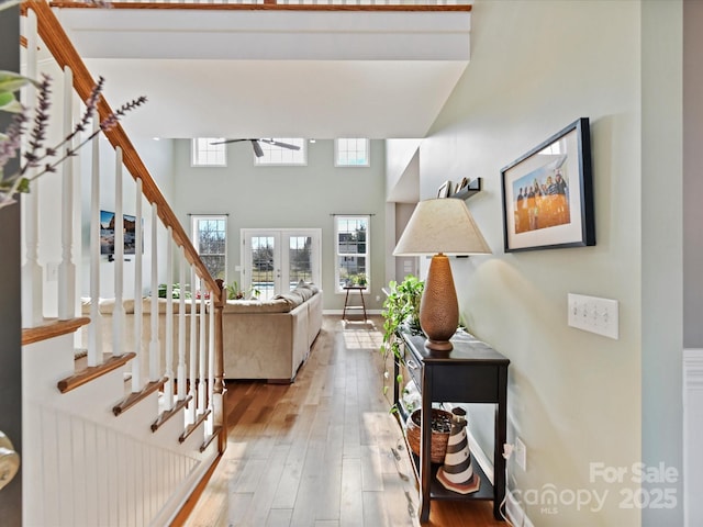 interior space with wood-type flooring, french doors, and a high ceiling