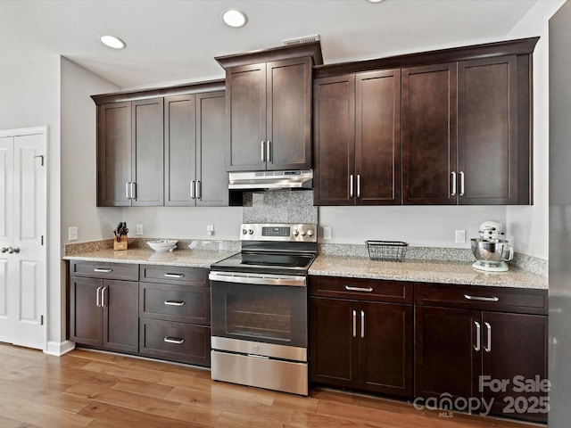 kitchen with dark brown cabinets, light stone counters, light wood-type flooring, and stainless steel range with electric stovetop