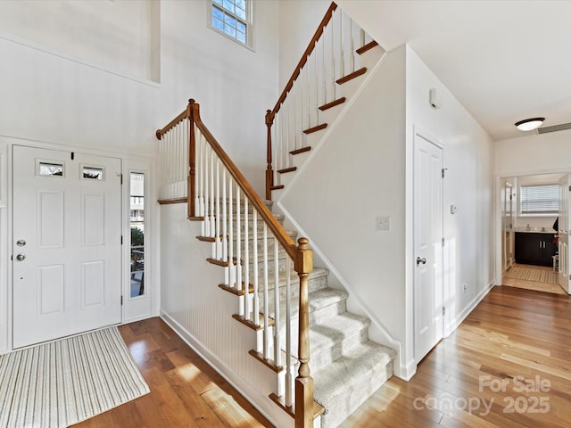 foyer featuring a towering ceiling and hardwood / wood-style floors