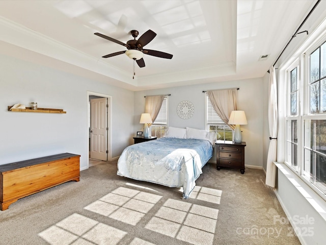 bedroom featuring light carpet, ceiling fan, and a tray ceiling