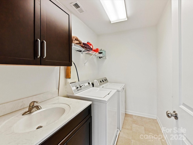 laundry room featuring cabinets, sink, and washer and clothes dryer