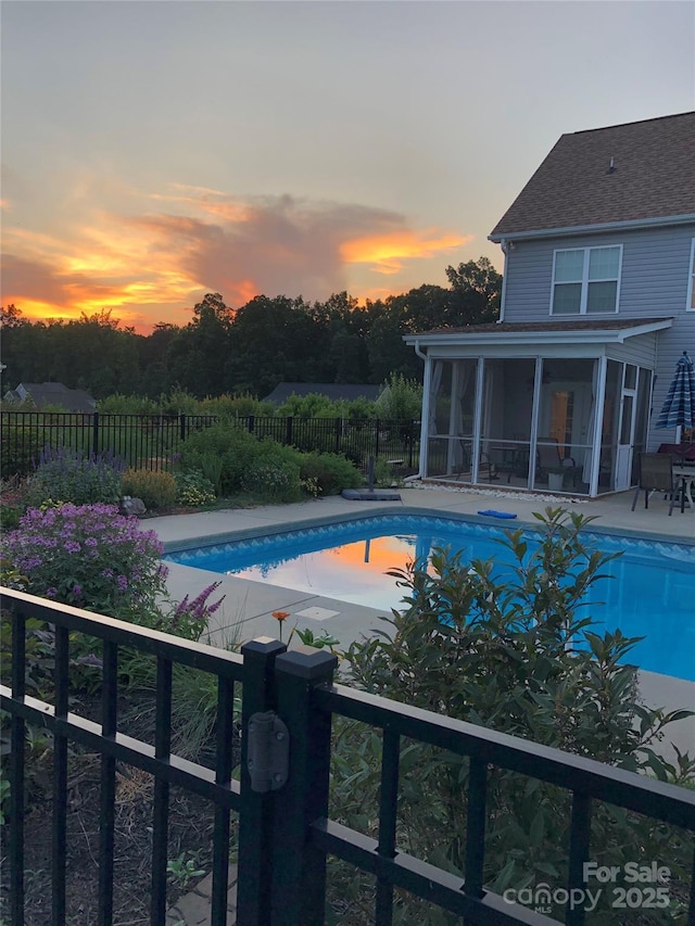 pool at dusk with a sunroom