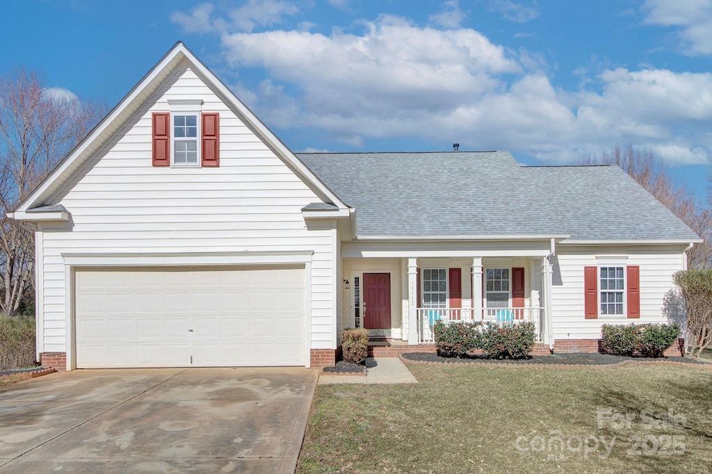 view of property with a garage, covered porch, and a front yard