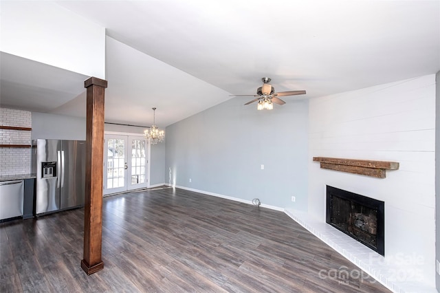 unfurnished living room with dark wood-type flooring, ceiling fan with notable chandelier, vaulted ceiling, and french doors