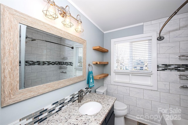 bathroom with crown molding, vanity, toilet, and a tile shower