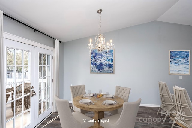 dining space featuring vaulted ceiling, dark hardwood / wood-style floors, a notable chandelier, and french doors