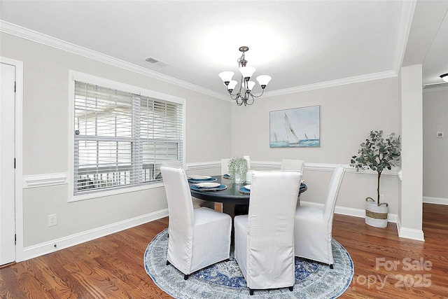 dining space featuring visible vents, a chandelier, wood finished floors, and ornamental molding