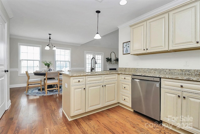 kitchen featuring a peninsula, cream cabinetry, light wood-type flooring, dishwasher, and decorative light fixtures