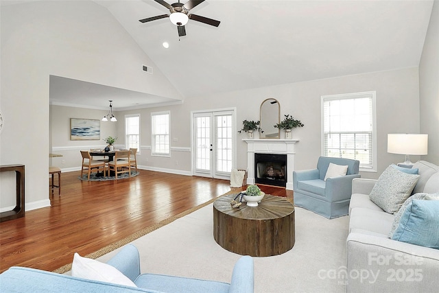 living area with visible vents, a fireplace, wood finished floors, and a wealth of natural light