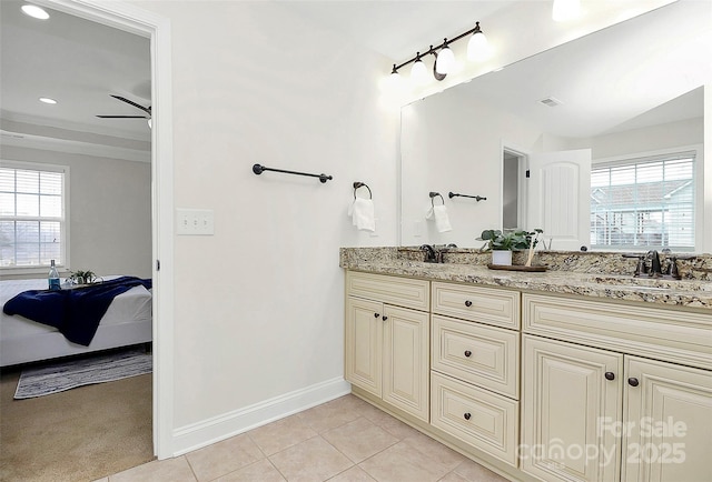 ensuite bathroom featuring double vanity, baseboards, tile patterned floors, ensuite bathroom, and a sink