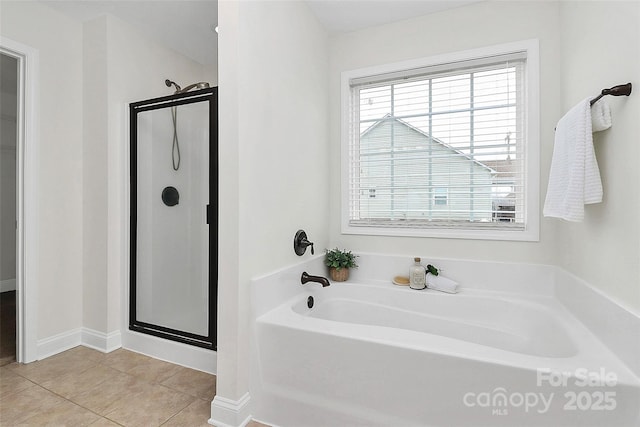 bathroom with a stall shower, a bath, and tile patterned floors