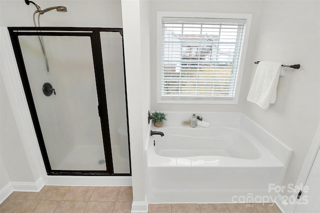 bathroom with tile patterned flooring, a bath, and a shower stall