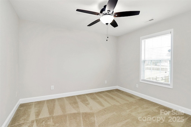 unfurnished room with carpet floors, visible vents, ceiling fan, and baseboards