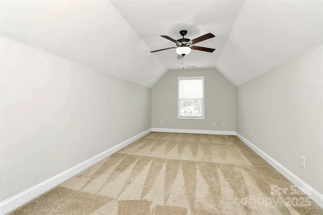 additional living space featuring visible vents, baseboards, a ceiling fan, light colored carpet, and lofted ceiling