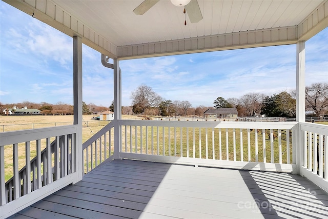 wooden terrace with ceiling fan and a yard