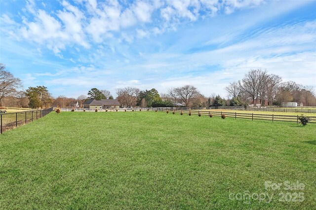 view of yard with a rural view and fence