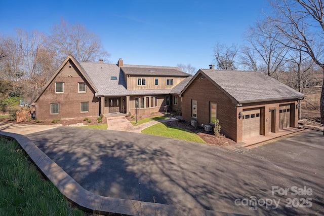 view of front of home featuring brick siding and a chimney