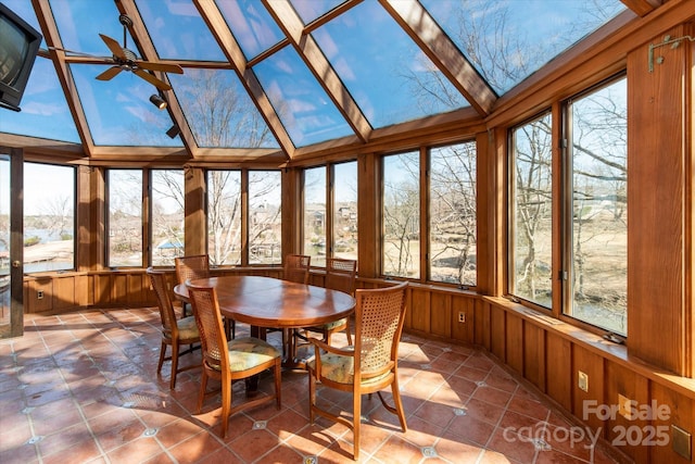 sunroom featuring a ceiling fan, vaulted ceiling, and plenty of natural light