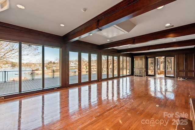 unfurnished room with light wood-style floors and beam ceiling