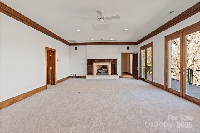 unfurnished living room featuring light carpet, baseboards, crown molding, a fireplace, and recessed lighting