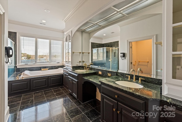 bathroom with double vanity, ornamental molding, a garden tub, a shower stall, and a sink