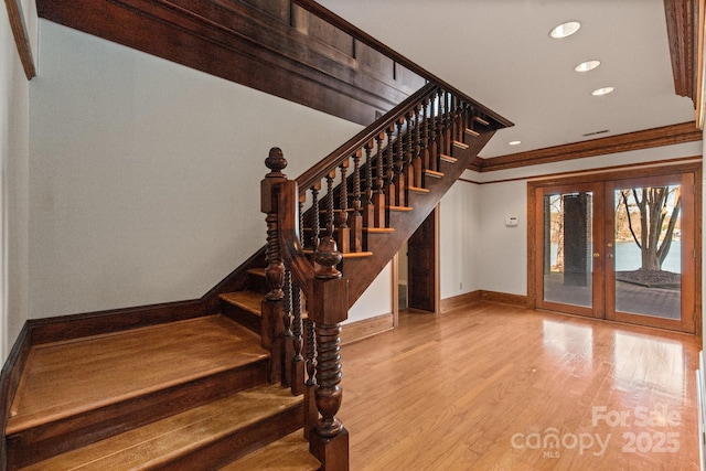 staircase with french doors, recessed lighting, ornamental molding, wood finished floors, and baseboards