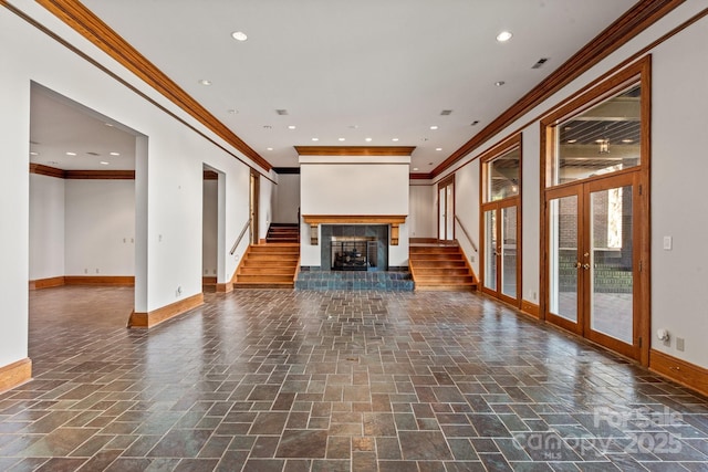 unfurnished living room with french doors, recessed lighting, a fireplace with raised hearth, baseboards, and stairs