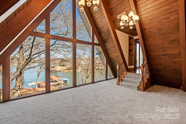 unfurnished living room featuring a water view, a healthy amount of sunlight, and carpet floors