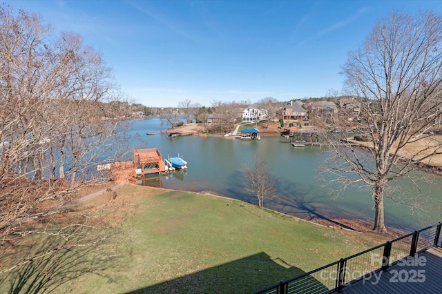 exterior space featuring a lawn, a water view, and fence