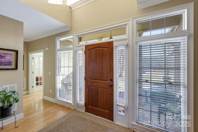 entryway featuring crown molding and light hardwood / wood-style flooring