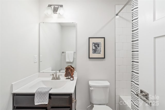 full bathroom with vanity, tiled shower / bath, and toilet