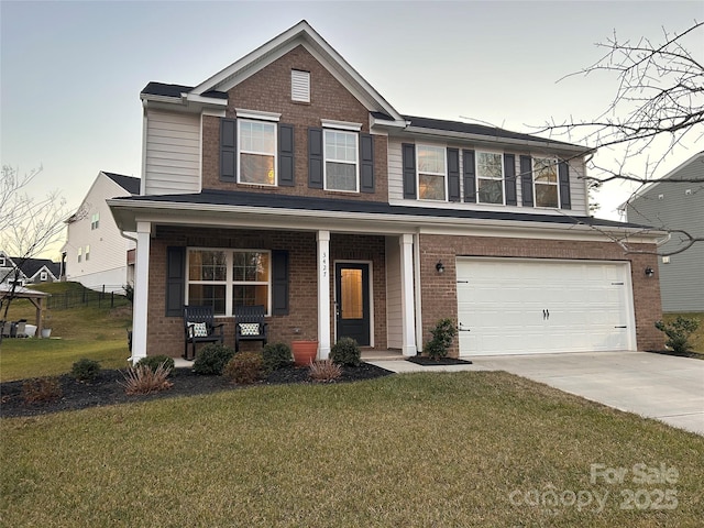 view of front of house featuring a garage, a front yard, and a porch