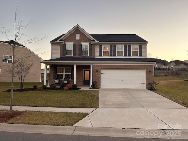 view of front of home with a garage, a yard, and covered porch