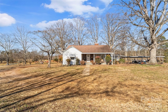 exterior space featuring a carport, covered porch, and a front lawn