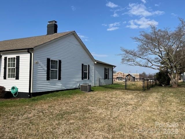 rear view of house featuring a yard and central air condition unit