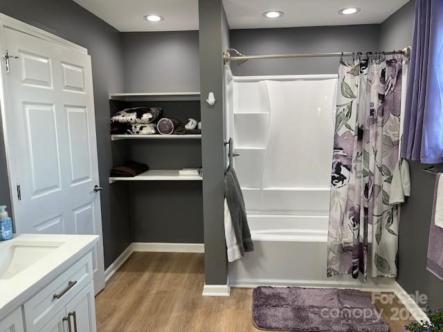 bathroom with shower / bath combination with curtain, vanity, and wood-type flooring