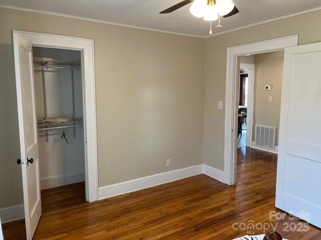 unfurnished bedroom with dark hardwood / wood-style flooring, ornamental molding, a closet, and ceiling fan