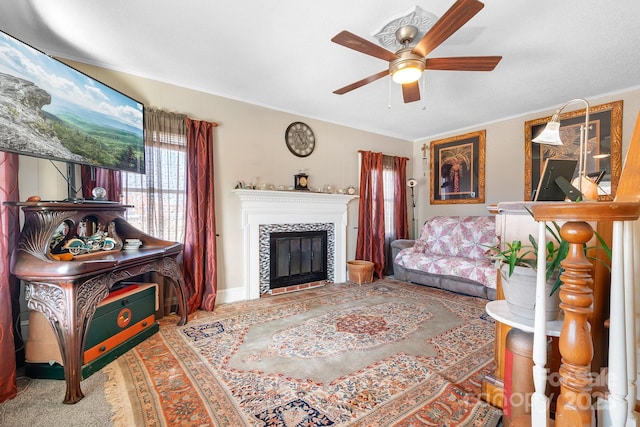 living room featuring ornamental molding, ceiling fan, and a fireplace