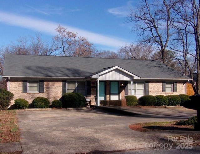 single story home featuring brick siding and driveway