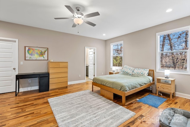 bedroom featuring connected bathroom, light hardwood / wood-style floors, and ceiling fan
