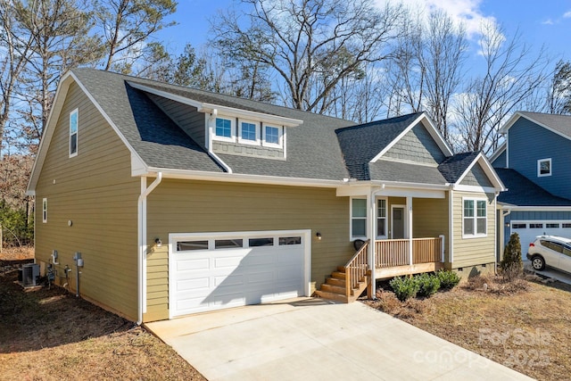 view of front of home with central AC unit, a garage, and covered porch