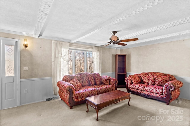 living room featuring ceiling fan, carpet, crown molding, and a textured ceiling