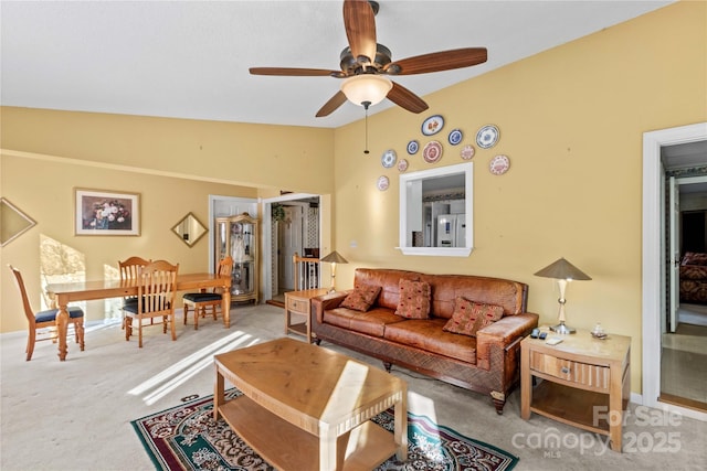 carpeted living room featuring ceiling fan and vaulted ceiling